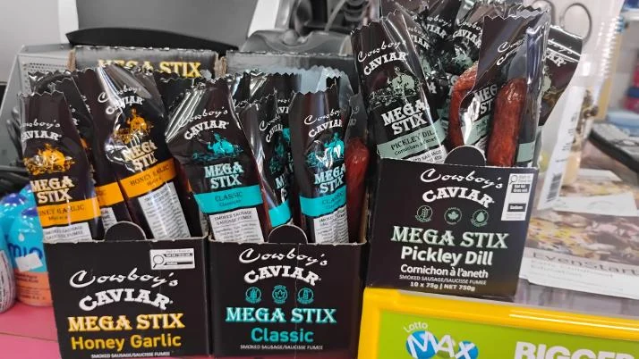 Cowboy’s Caviar Mega Stix meat snack sticks in a counter display at Northmount Convenience Store